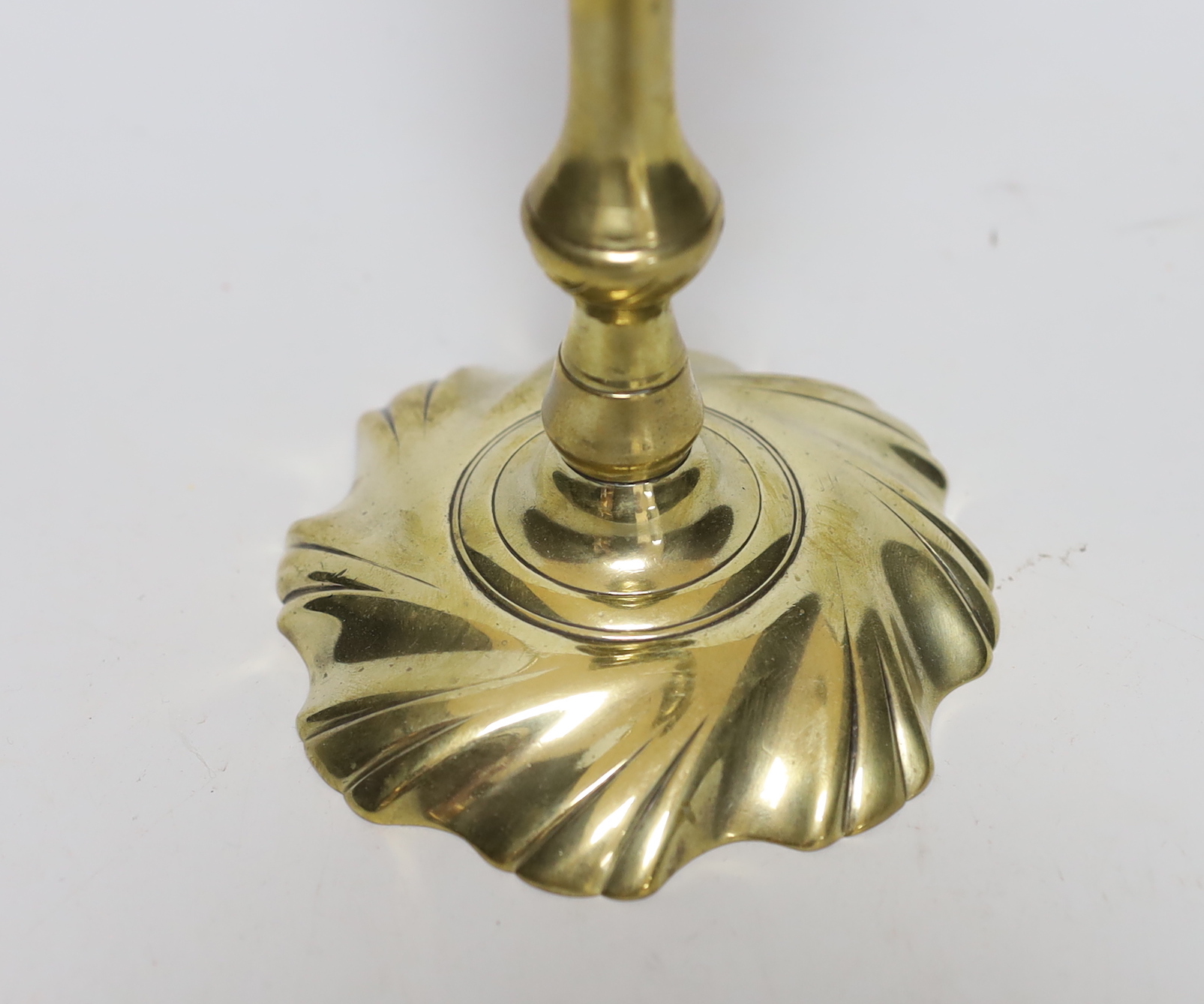 A mid 18th century swirl base brass candlestick, 21cm